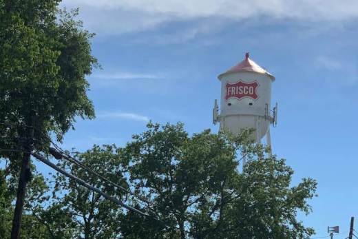The Frisco water tower above the trees
